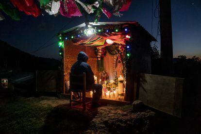 Un hombre reza en una pequeña capilla a la virgen de Guadalupe instalada en uno de los caminos rurales de la montaña. 