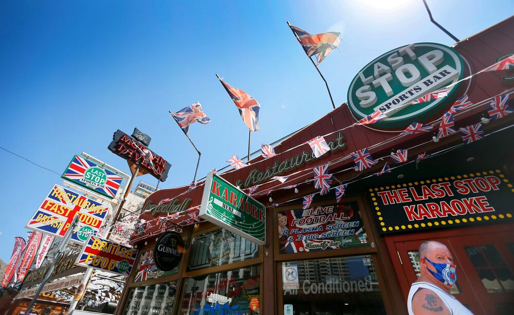 Un turista pasea, este domingo, por una calle de Benidorm en la que se ven numerosos negocios cerrados.