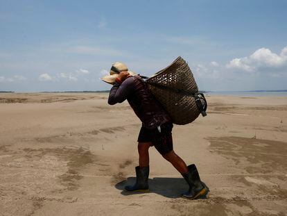 Un hombre carga un paquete de ayuda cerca de Careiro da Varzea en Brasil, el 24 de octubre 2023.