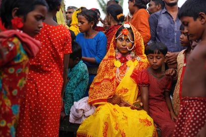 Una bangladesí de 14 años posa, sentada junto a amigos y vecinos, en el día de su boda.