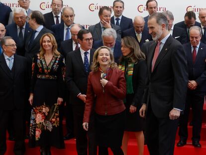 El rey Felipe VI sonríe en presencia de la ministra de Economía, Nadia Calviño y del presidente de la CEOE, Antonio Garamendi, en la Cámara de Comercio este miércoles en Madrid.