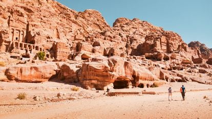 Dos turistas junto a las cuevas y tumbas reales de la antigua ciudad de Petra (Jordania)