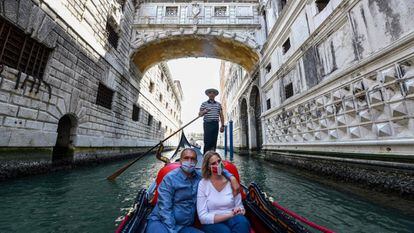 Una pareja disfruta de un paseo en góndola bajo el Puente de los Suspiros de Venecia (Italia).