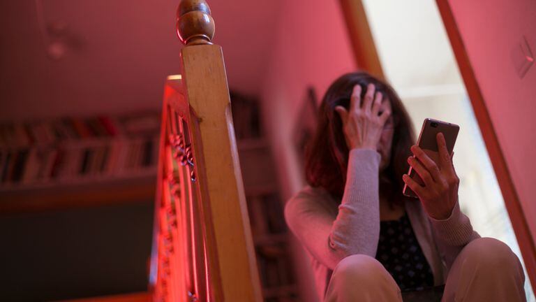 Una mujer consulta el móvil en su casa, durante el periodo de confinamiento.