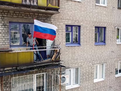 Un vecino de Lisichansk ondea la bandera de Rusia en su balcón.