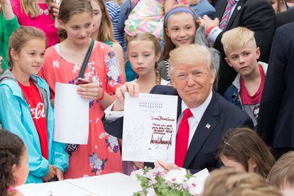 El presidente Donald Trump sostiene una carta firmada que escribió a un miembro de las Fuerzas Armadas de los EEUU, el 17 de abril de 2017, durante el 139 ° 'Easter Egg Roll' en la Casa Blanca, en Washington, D.C.
