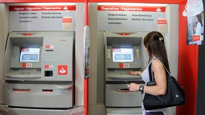 Una mujer retira dinero de un cajero de Banco Santander, en São Paulo (Brasil).