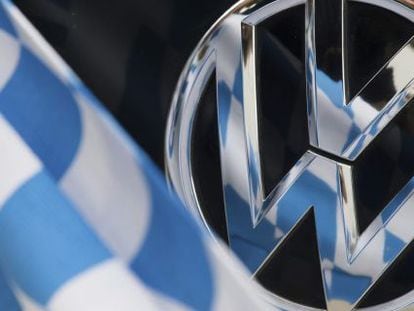 Una bandera de cuadros azules y blancos, reflejada sobre la insignia de un coche Volkswagen