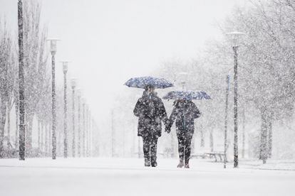 Una pareja camina bajo la nieve, en Pamplona.