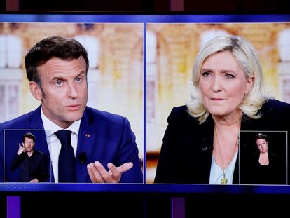 Una imagen muestra pantallas de televisión que muestra una transmisión en vivo entre el presidente francés y el candidato Emmanuel Macron y Marine Le Pen, el miércoles 20 de abril de 2022.
