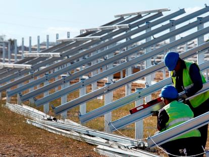 Dos operarios trabajan en una nueva instalación de solar fotovoltaica.
