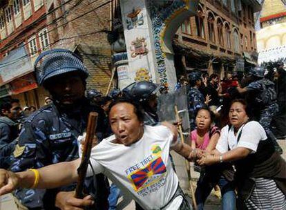 Un policía nepalés detiene a un activista tibetano en Katmandú, durante las protestas en el 50º aniversario del levantamiento contra China.