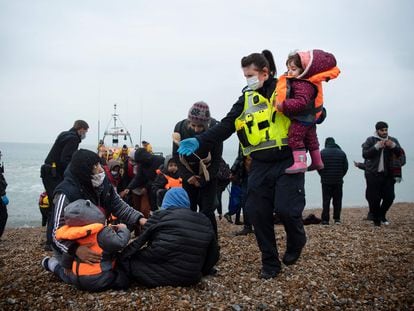 Un agente de fronteras británico ayuda a niños migrantes llegados a Dungeness, Reino Unido, el pasado 24 de noviembre.