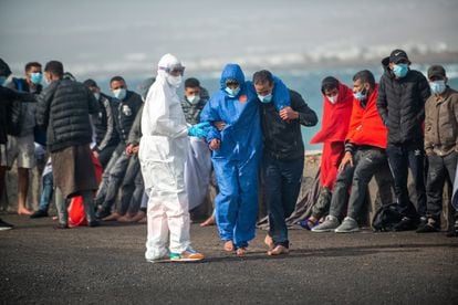Inmigrantes rescatados en el mar son ayudados en el puerto de Lanzarote por miembros del servicio de salvamento marítimo.