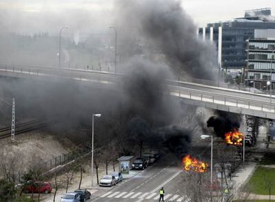 Dos vehículos en llamas instantes después de la explosión de la furgoneta bomba de ayer en Madrid.