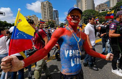 Un joven con el cuerpo pintado con la bandera de Venezuela participa en la marcha en apoyo a Guaidó para exigir la entrada de ayuda humanitaria.