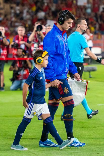 Morata, que lleva unos auriculares de cancelación de ruido, salta al campo en La Cartuja con un niño autista.