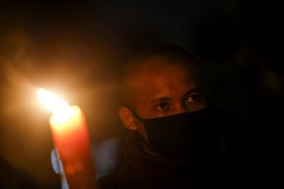 Monjes budistas portan máscaras durante una protesta organizada contra el gobierno en Rangún (Birmania).