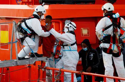 Un miembro de la Cruz Roja ayuda a bajar del barco a un niño en el puerto de Arguineguín (Gran Canaria) este miércoles.