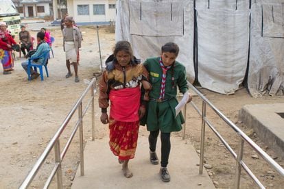 Una vez en el campamento, niños voluntarios de la escuela local acomodan a los pacientes como Ram Maya Majhi (de 50 años) y los preparan para la intervención.
