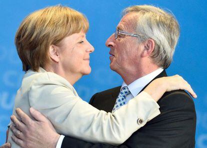 Merkel y Juncker se abrazan durante la campa&ntilde;a electoral de mayo.
