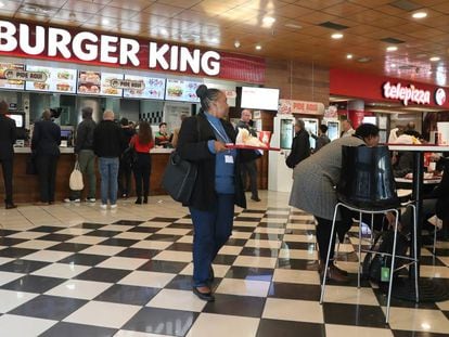 Varios asistentes a la cumbre del clima consumen comida rápida de Burger King en envases de plástico.