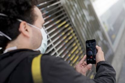 Un hombre protegido con mascarilla realiza una videollamada por su teléfono móvil, una de las formas más habituales de comunicarse durante la pandemia.