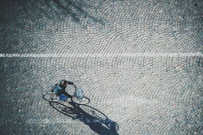 Una persona circula en bicicleta por la calle.
