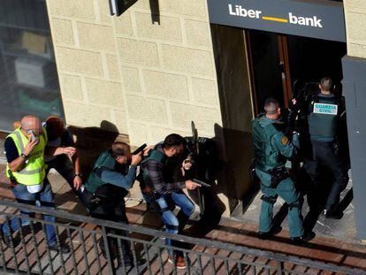La Guardia Civil entra en la surcursal de Liberbank de Cangas de On&iacute;s para detener al atracador, que se hab&iacute;a disparado.