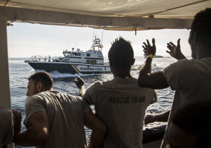 Personal de rescate del Open Arms hacen gestos a una patrullera de la Guardia Civil a su llegada al puerto de Barcelona, el 4 de julio de 2018.