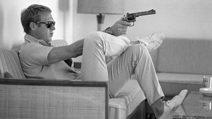 Steve McQueen, sentado en el sofá de su casa de Palm Springs (California) con una pistola en la mano, en mayo de 1963.