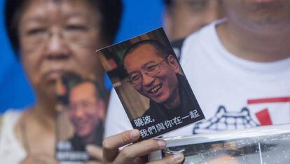 Un activista de la Alianza de Hong Kong de Apoyo a los Movimientos Democr&aacute;ticos Patri&oacute;ticos de China muestra una postal en apoyo al disidente chino Liu Xiaobo.
