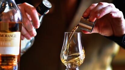 Un camarero sirve una copa de whisky en un 'pub' de Edimburgo, en Escocia (Reino Unido).