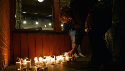 Una mujer enciende una vela en memoria de las víctimas del ataque en Trollhättan (Suecia).