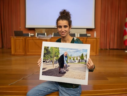 La fotógrafa Marina Escudero sujeta una imagen de Esperanza Pérez, pala en mano y cavando en un cementerio.