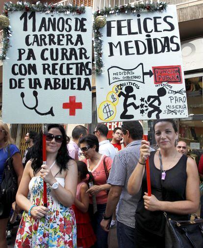 Miles de personasparticipan en las protestas de Murcia. En la imagen, dos de las participantes, con pancartas contra las emdidas de recorte del Gobierno