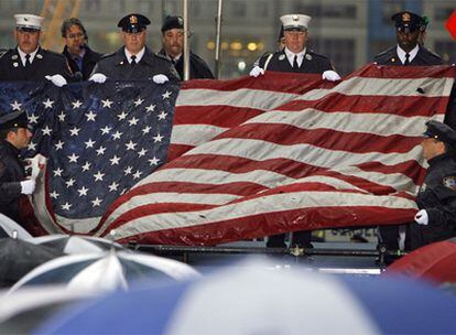 Un grupo de soldados y policías de Nueva York despliegan la bandera recuperada de las Torres Gemelas en el octavo aniversario del atentado.