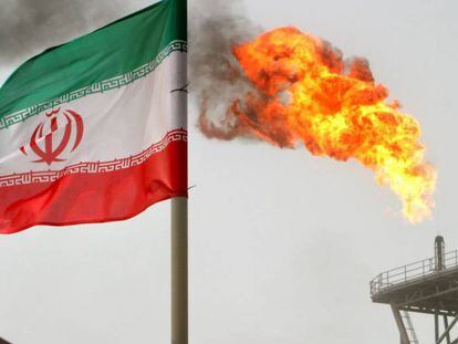 Una llamarada de gas en una plataforma petrol&iacute;fera de Soroush junto a una bandera iran&iacute;.