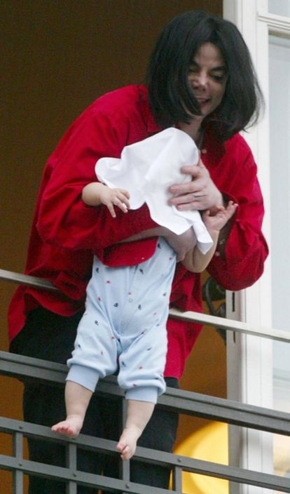 Michael Jackson se asoma por una ventana del Adlon Hotel de Berlín con su hijo de nueve meses en 2002.