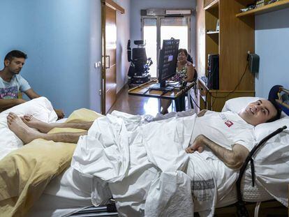 Rafa Botella Martí, en su casa, con su amigo Pau y su madre Marisa.