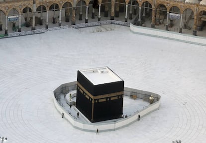 Agentes de la policía vigilan la Kaaba, el gran cubo que se encuentra en la Gran Mezquita de La Meca, en Arabia Saudí, el pasado 6 de marzo. El lugar santo de los musulmanes se encontraba vacío en una medida para intentar luchar contra la epidemia del coronavirus. 