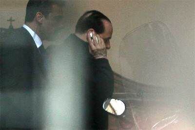 Silvio Berlusconi habla por el teléfono móvil a su llegada al palacio Grazioli, su residencia privada en Roma.