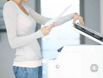 Una mujer utilizando una fotocopiadora.