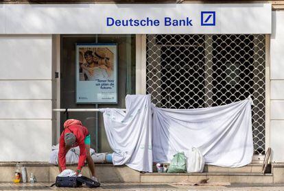 Una persona sin hogar, tras pasar la noche en la puerta de una entidad bancaria. 