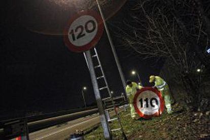 Dos operarios cambian los límites de velocidad en una autopista, en marzo pasado.