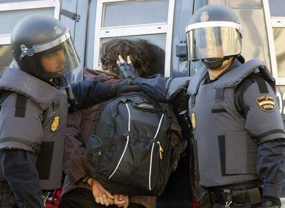 La policía custodia a un detenido durante los incidentes entre estudiantes y agentes en el centro de Valencia. Decenas de personas han sido detenidas desde el comienzo de las protestas, varias de ellas menores de edad.