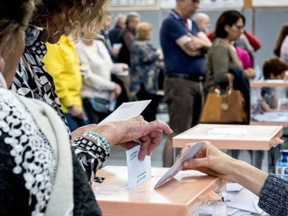 Voto en urna en un colegio electoral.