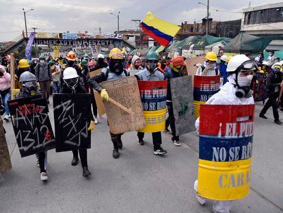Miembros de la primera línea caminan con escudos improvisados ​​mientras participan en una protesta contra el gobierno colombiano, en Bogotá, el 28 de mayo de 2021.