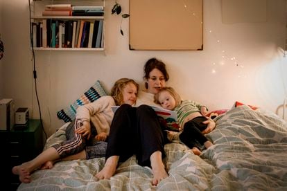 Una madre lee un cuento a sus hijas.