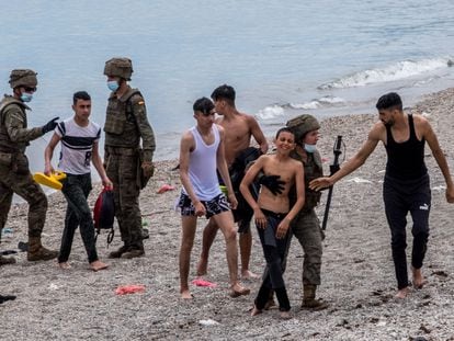 Varios menores llegan a las playas de Ceuta, donde son recibidos por miembros del Ejército.